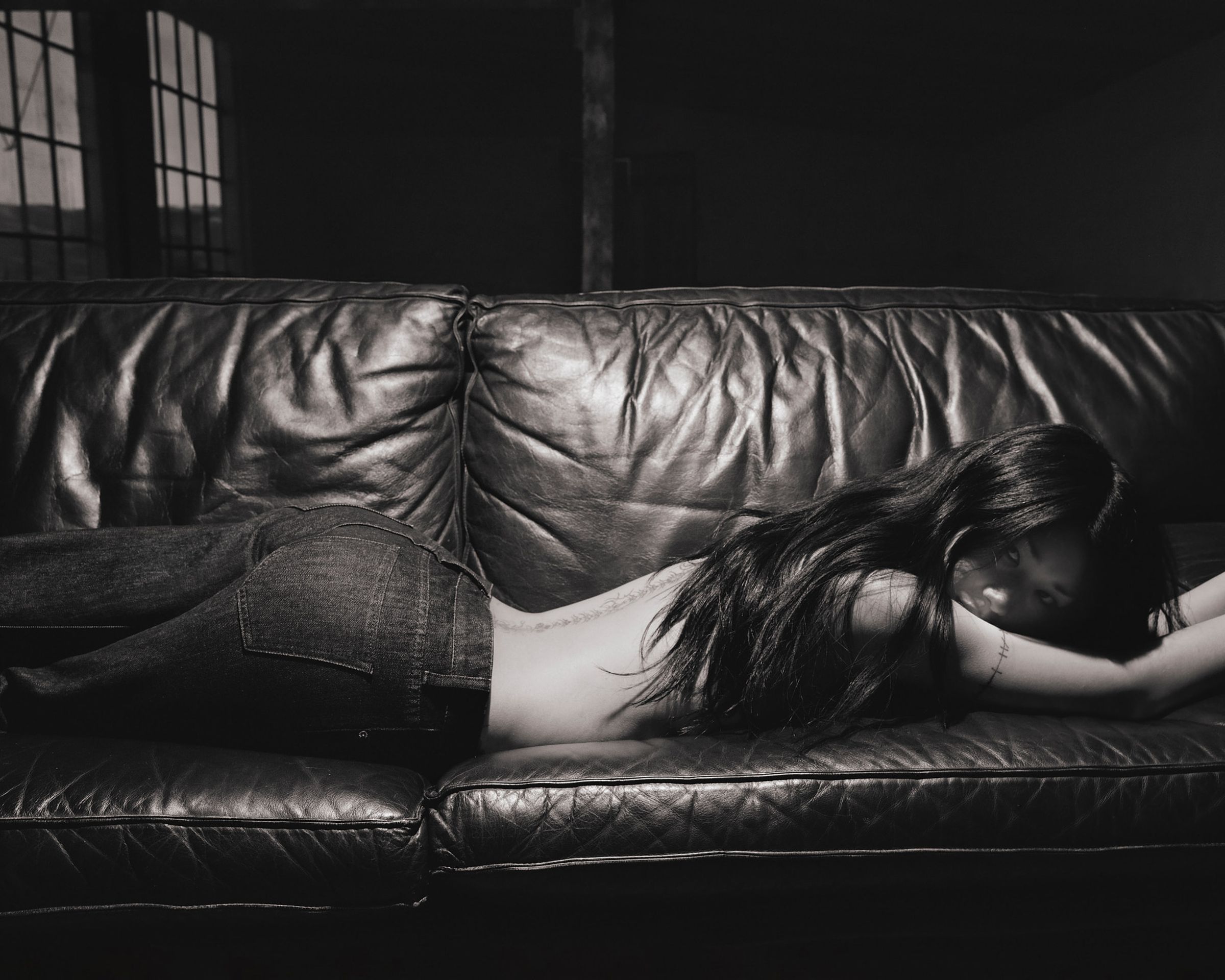 Tank Air SS26 Denim shot in Los Angeles by Tank Air. Model wearing Low Slung Jeans lying on couch.