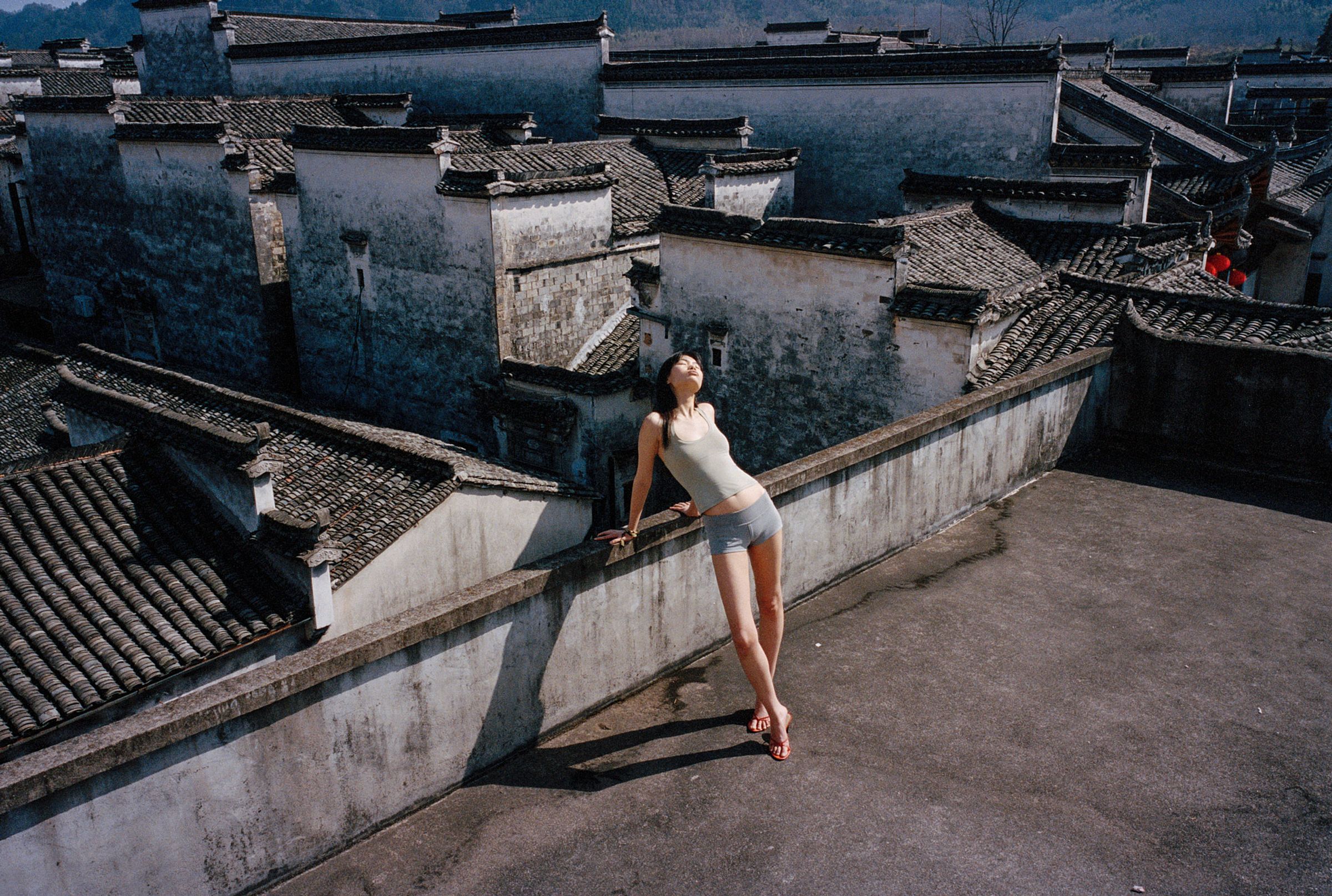 Tank Air SS26 Essentials shot in Nanping Village in Erika Kamano. Model wearing the Teardrop Halter in Celadon and Bliss Hot Pants in Grey while standing on rooftop.