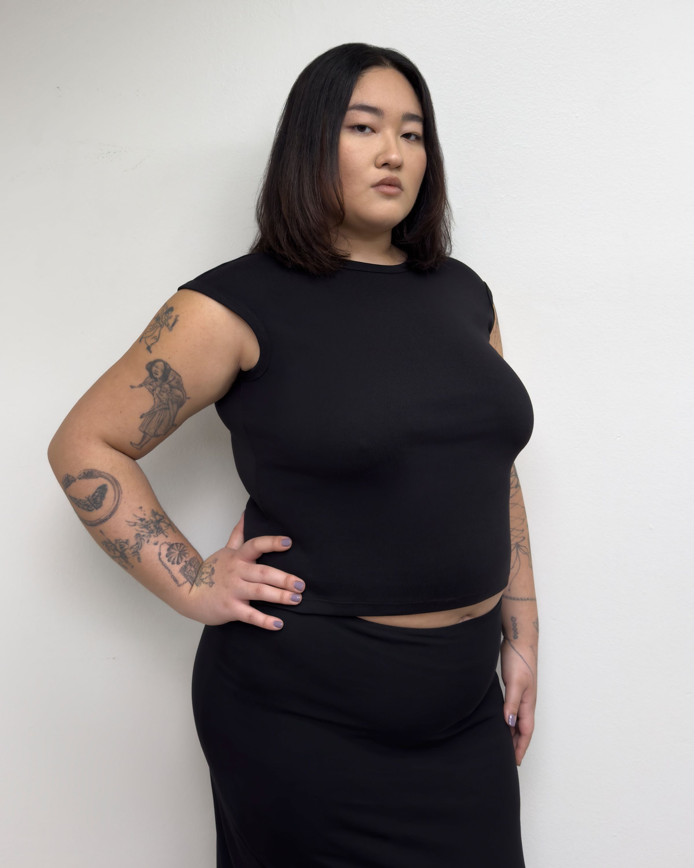 Tank Air SS25 Essentials shot in Los Angeles by Tank Air. Model wearing Corner Tee in Black against white wall.