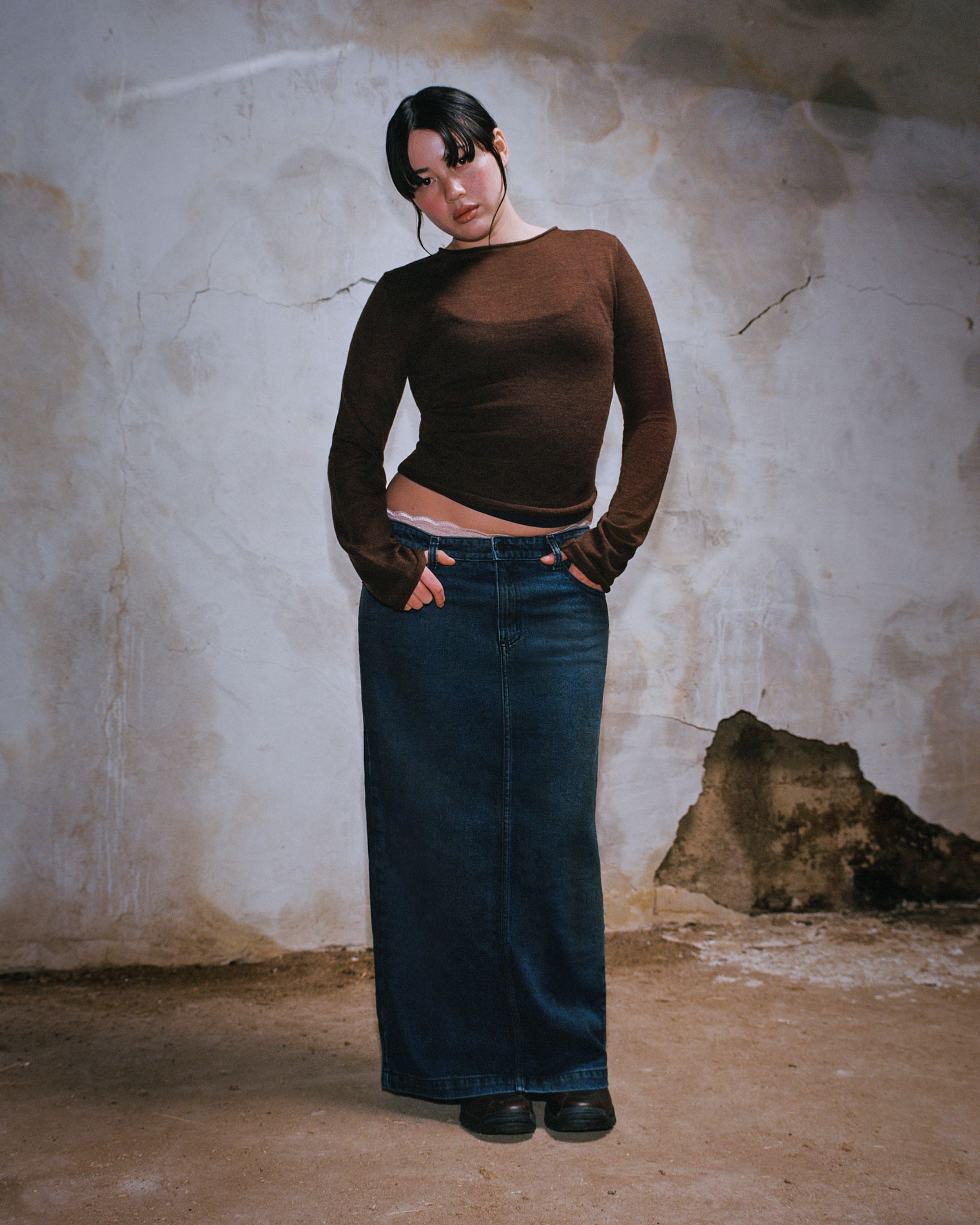 Tank Air SS24 Denim shot in Los Angeles by Tank Air. Model wearing the Cocoon Denim Maxi Skirt while standing against a wall.