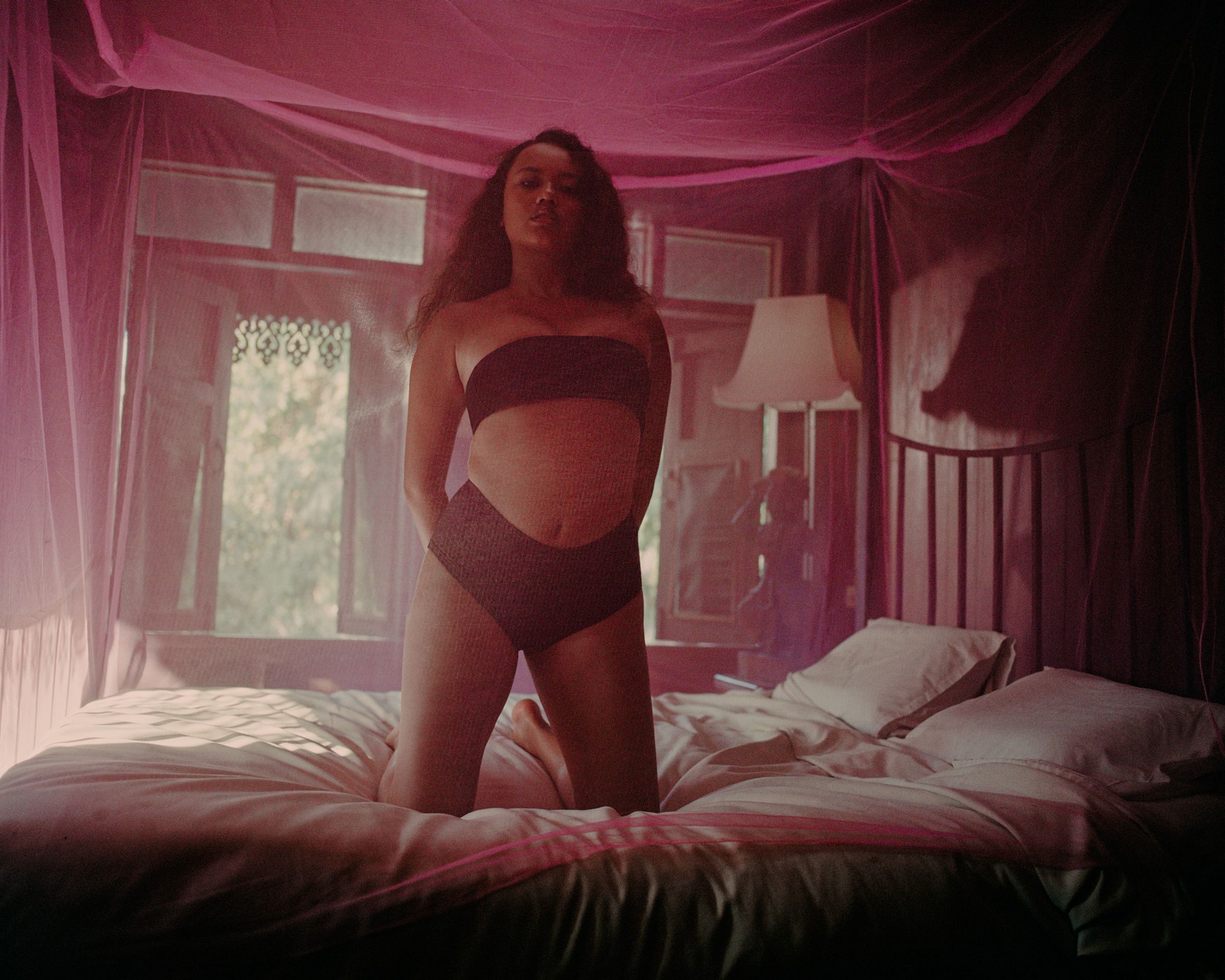 Tank Air SS24 ready-to-wear shot in Bangkok by Erika Kamano. Model wearing the Bandeau in Black while kneeling on bed.