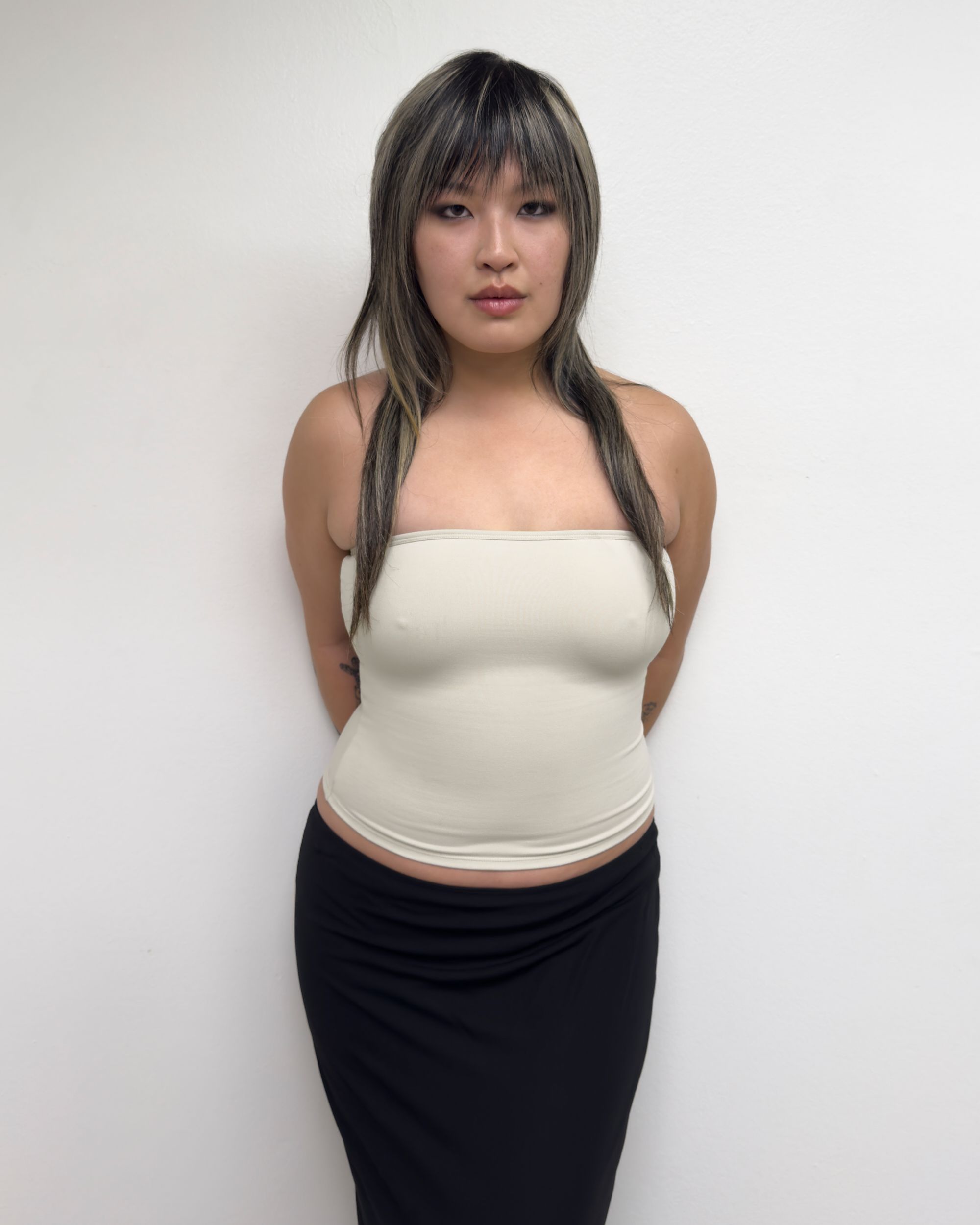 Tank Air SS25 Essentials shot in Los Angeles by Tank Air. Model wearing Tube Top in Soybean against white wall.