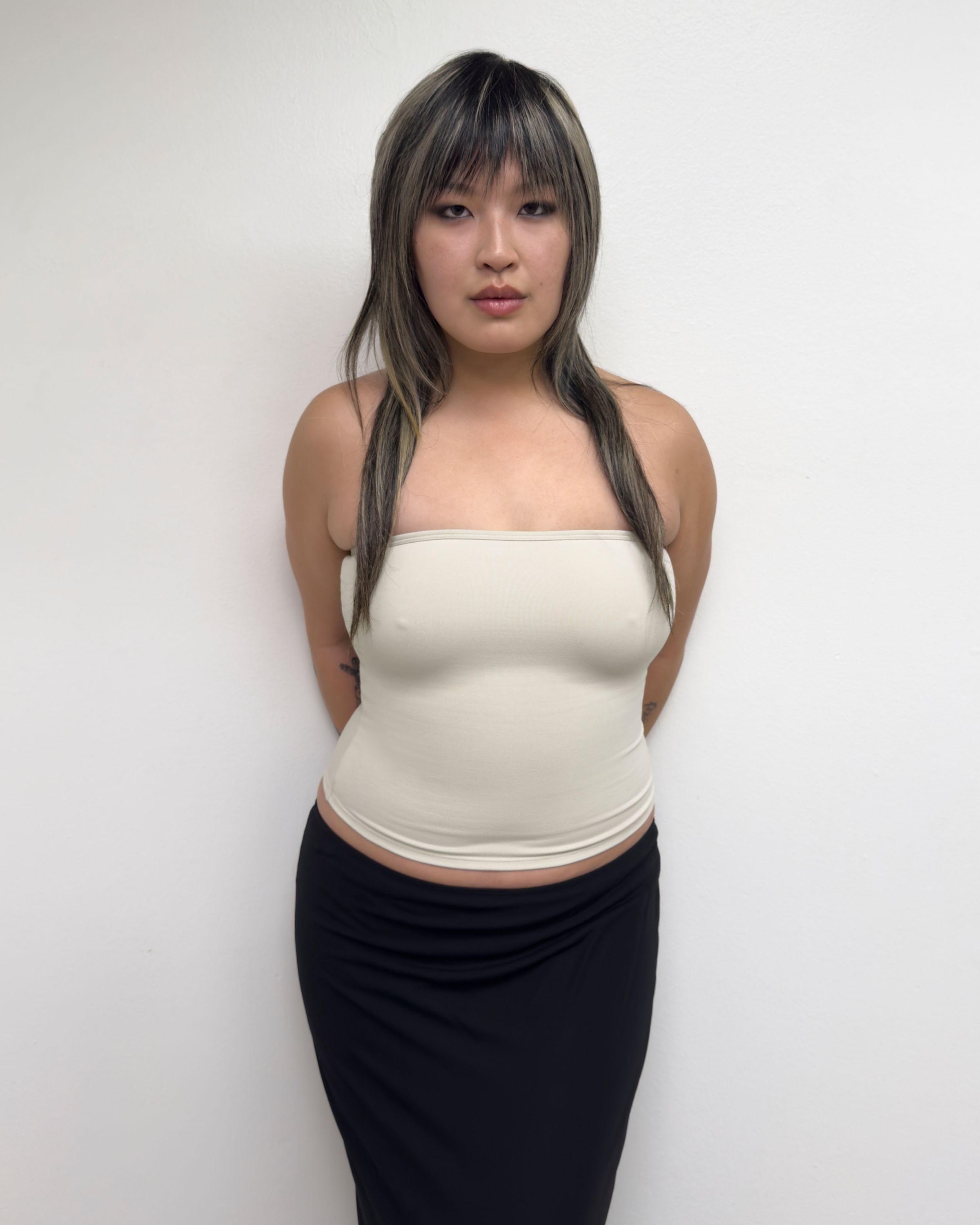 Tank Air SS25 Essentials shot in Los Angeles by Tank Air. Model wearing Tube Top in Soybean against white wall.