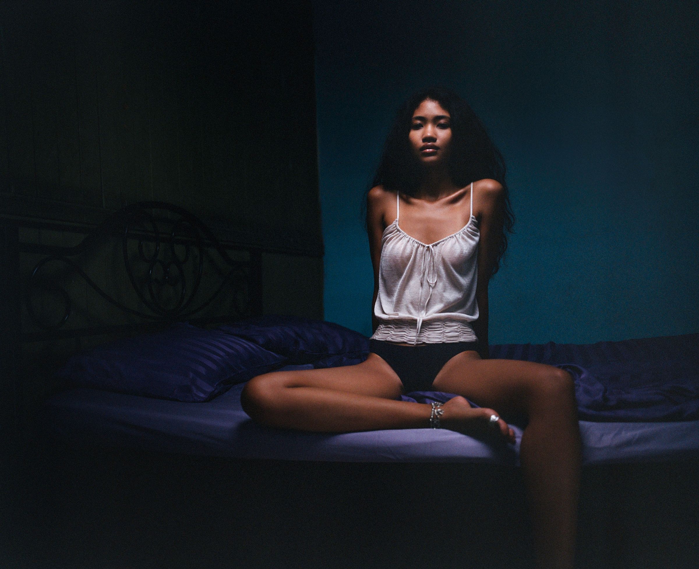 Tank Air SS25 ready-to-wear shot in Bangkok by Erika Kamano & Tank Air. Model wearing the Night Market Knit in Blush while sitting on a bed.