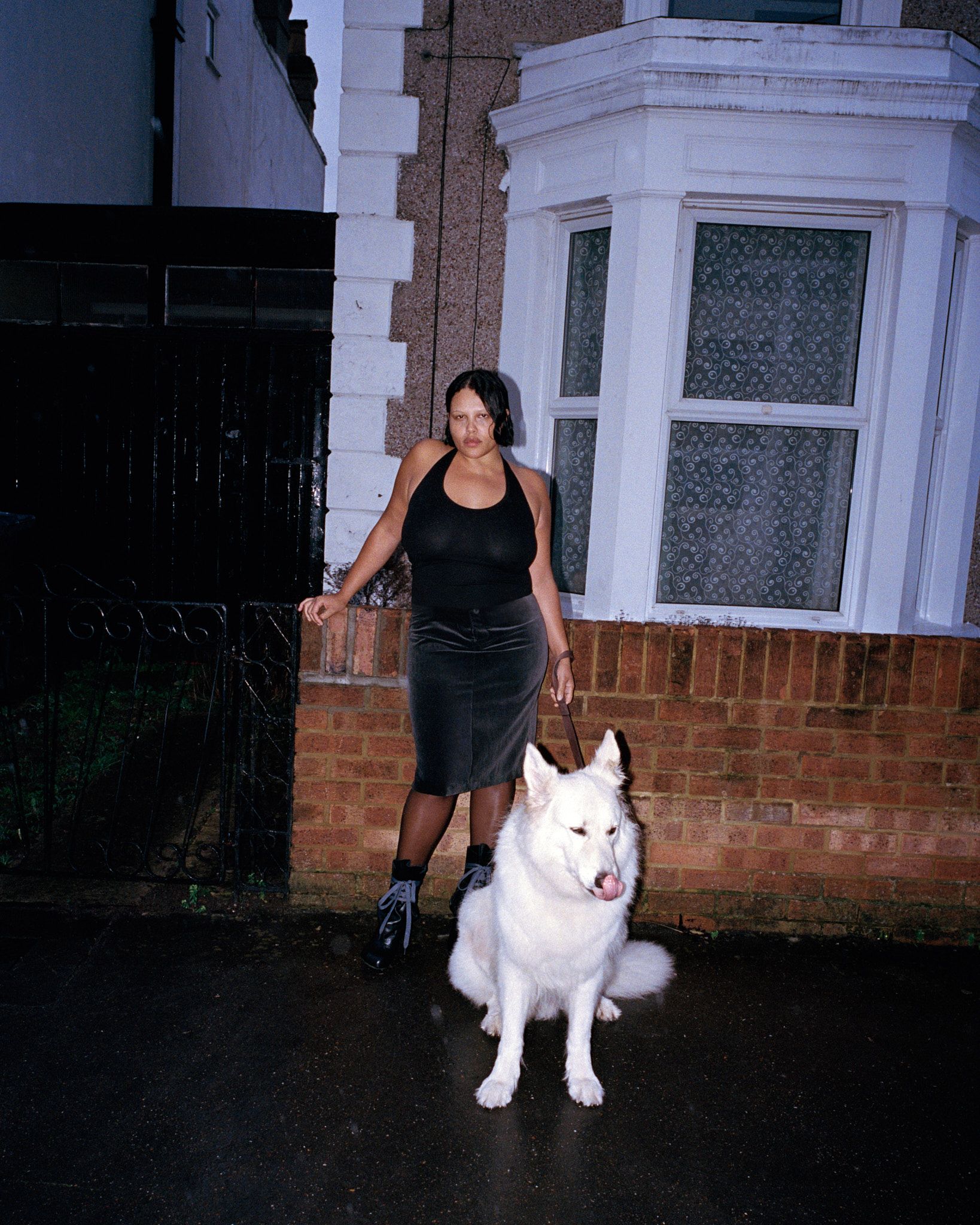 Tank Air SS26 Essentials shot in London by Erika Kamano. Model wearing the Teardrop Halter in Black with white dog standing in front of a home.