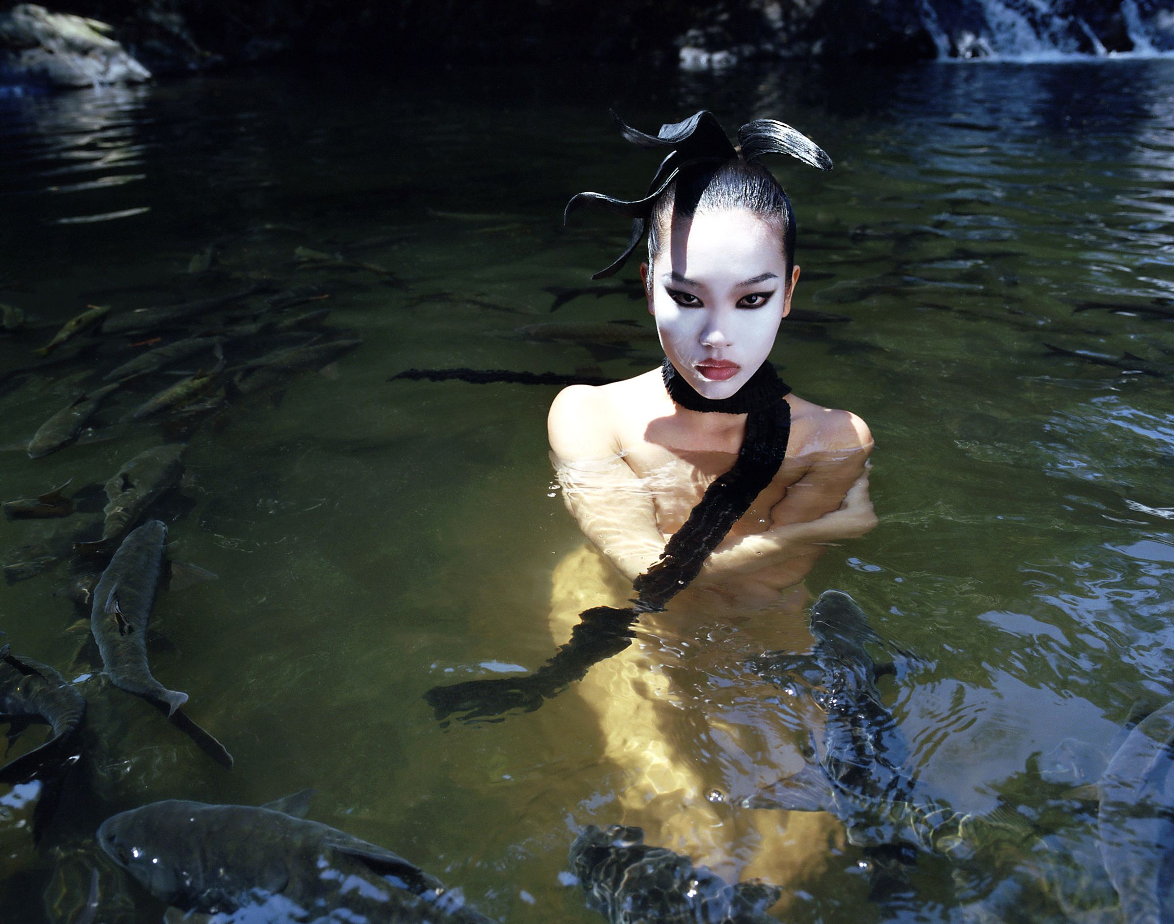Tank Air SS23 Ready-to-Wear shot in Bangkok by Erika Kamano. Model wearing the Thai Pleated Scarf in Black in water, surrounded by fish.