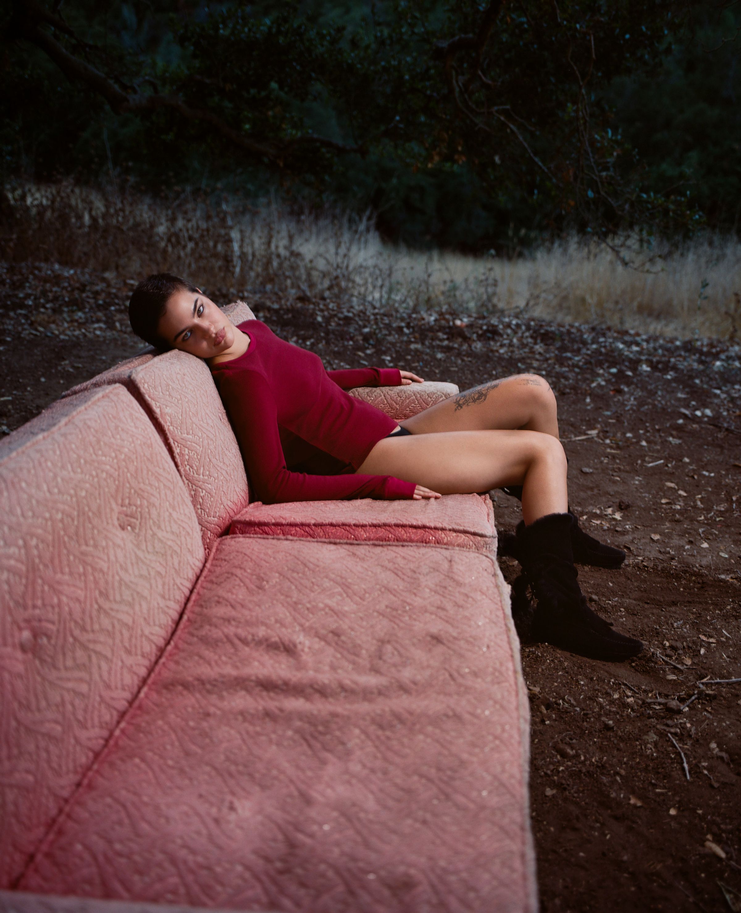 Tank Air FW25 Essentials shot in Los Angeles by Tank Air. Model wearing the Box Thermal in Blood while lying on a couch.