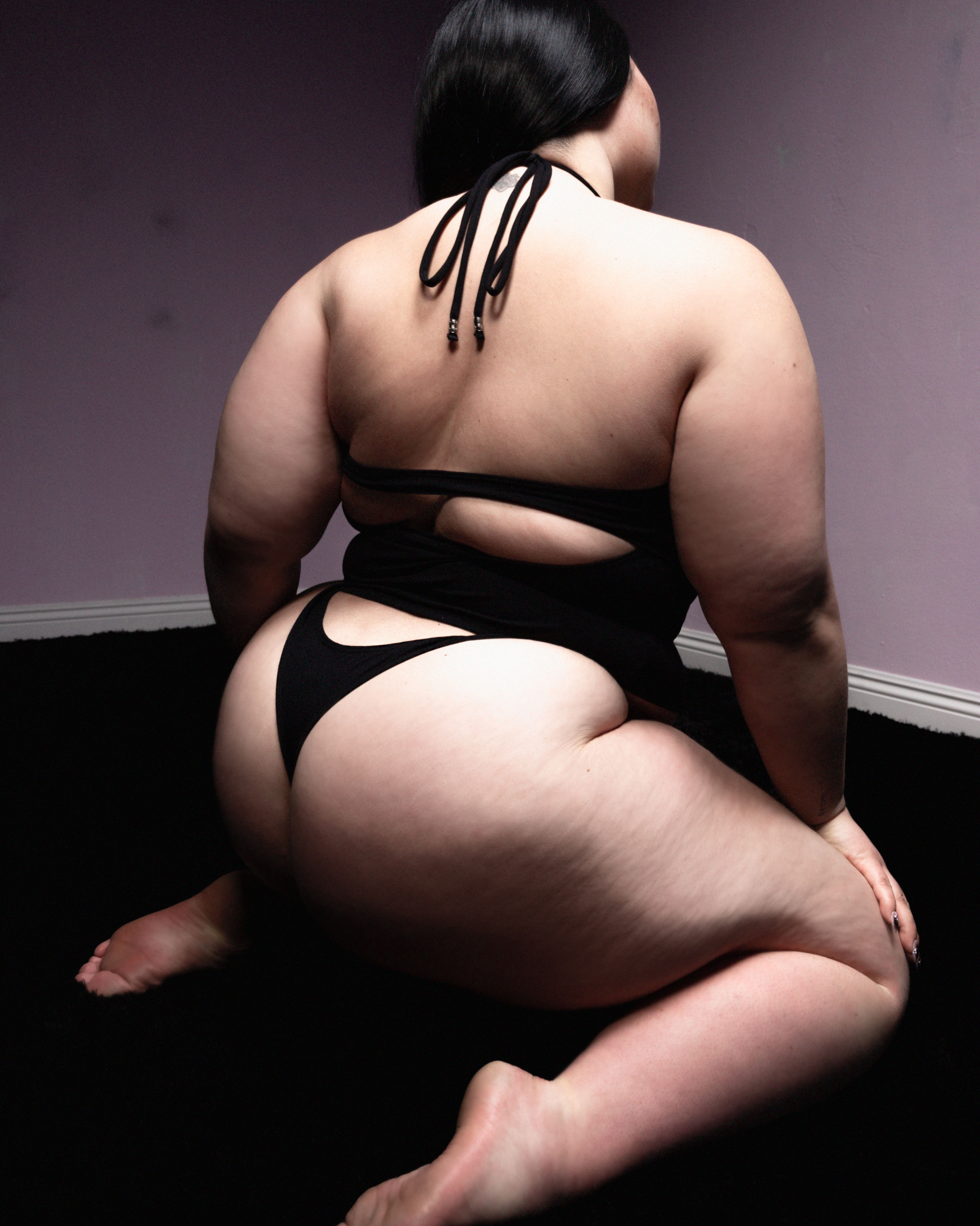Tank Air SS23 Essentials shot in Los Angeles by Erika Kamano. Model wearing the Spill Halter in Black while kneeling on the floor in a from the back.
