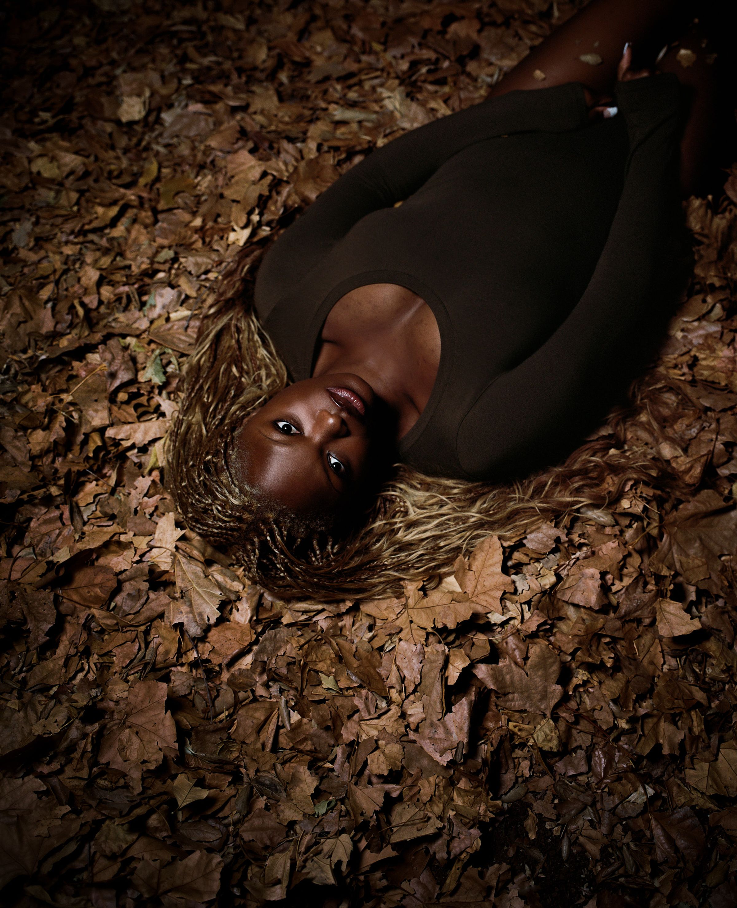 Tank Air FW25 Essentials shot in Los Angeles by Tank Air. Model wearing the Circle Top in Mud while lying in a pile of leaves.