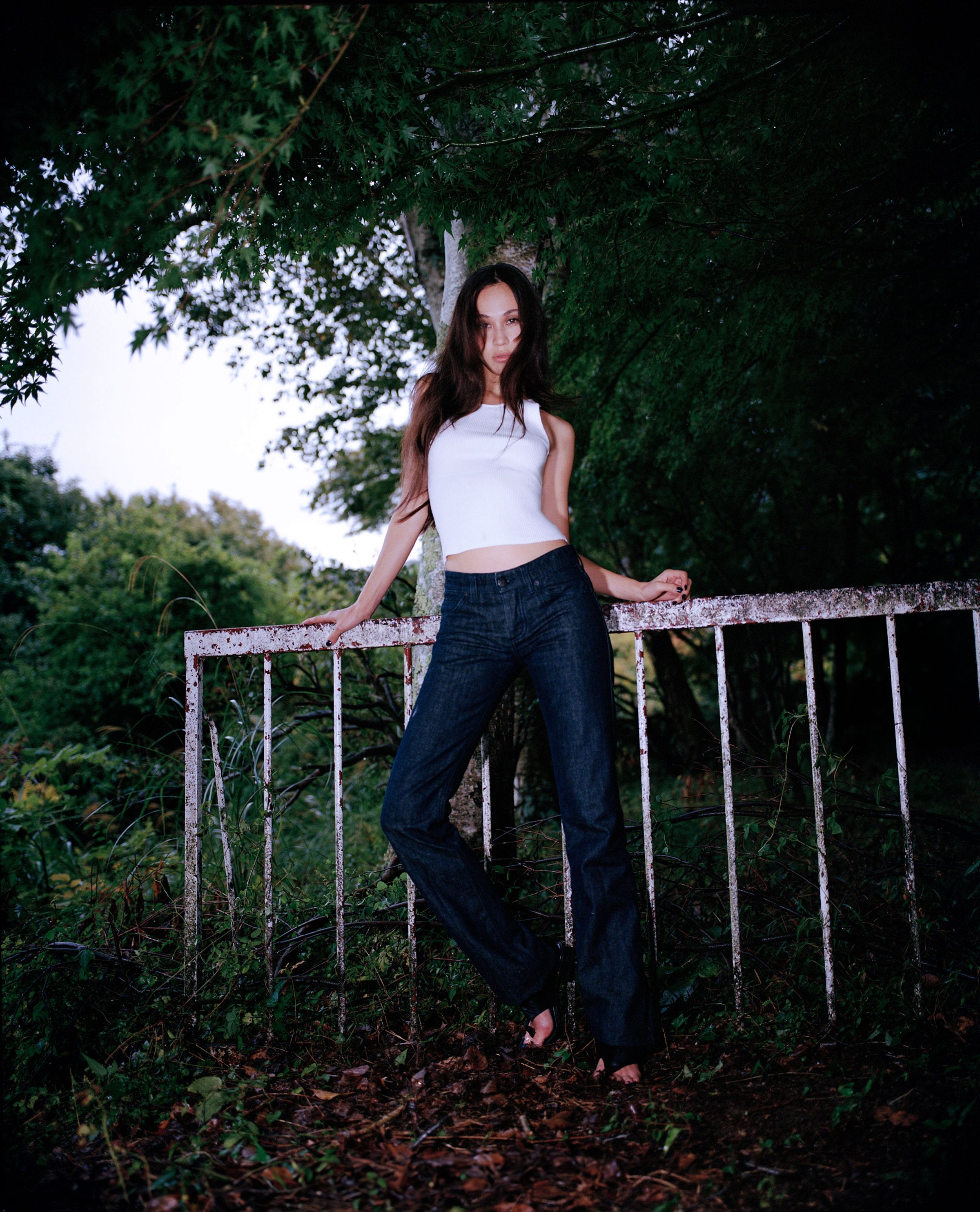 Tank Air FW24 ready-to-wear shot in Tokyo by Erika Kamano. Model wearing the Cute Knit Tank in Milk and Indigo Jeans in a mossy forest.
