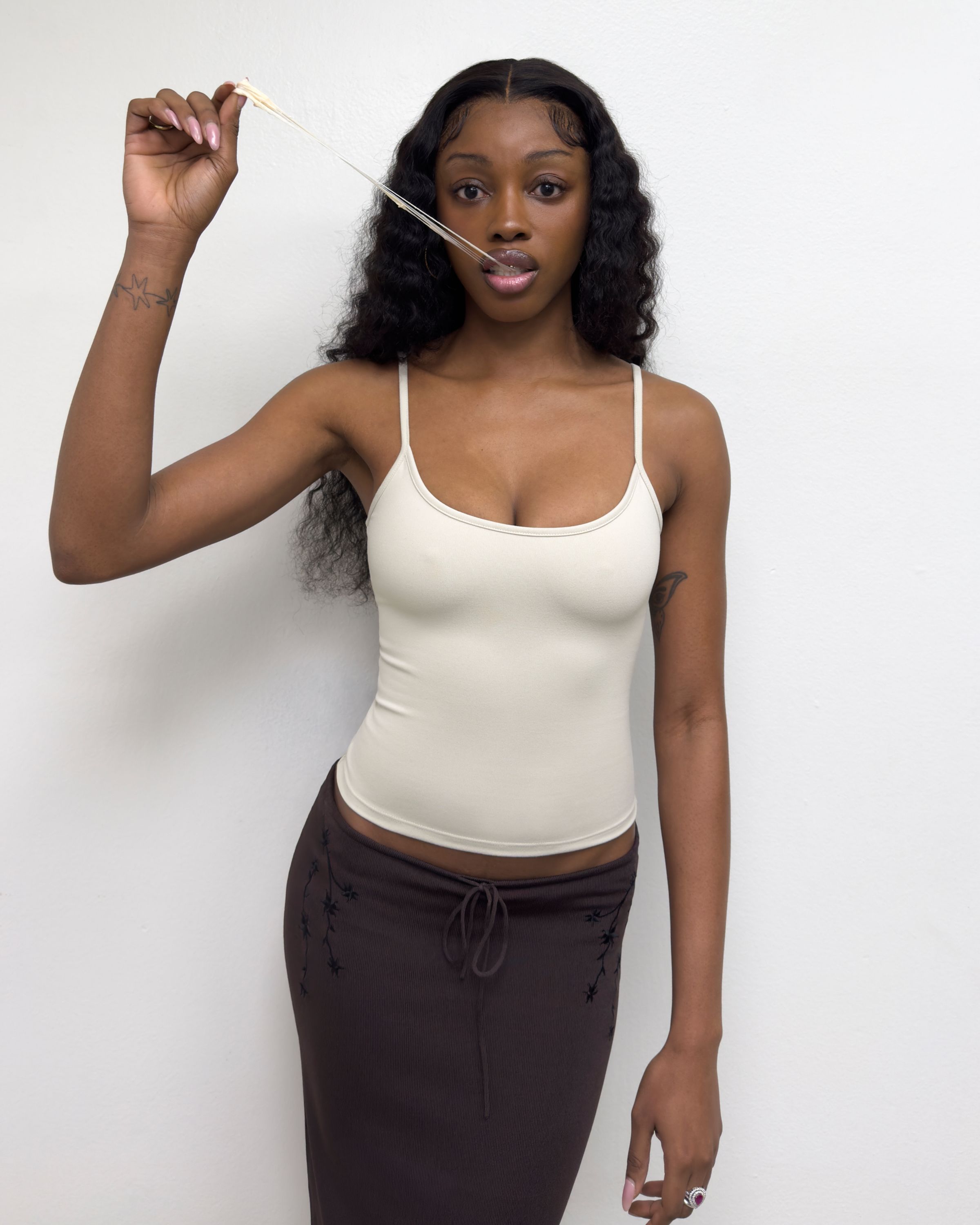 Tank Air SS25 Essentials shot in Los Angeles by Tank Air. Model wearing Studio Tank in Soybean against white wall.