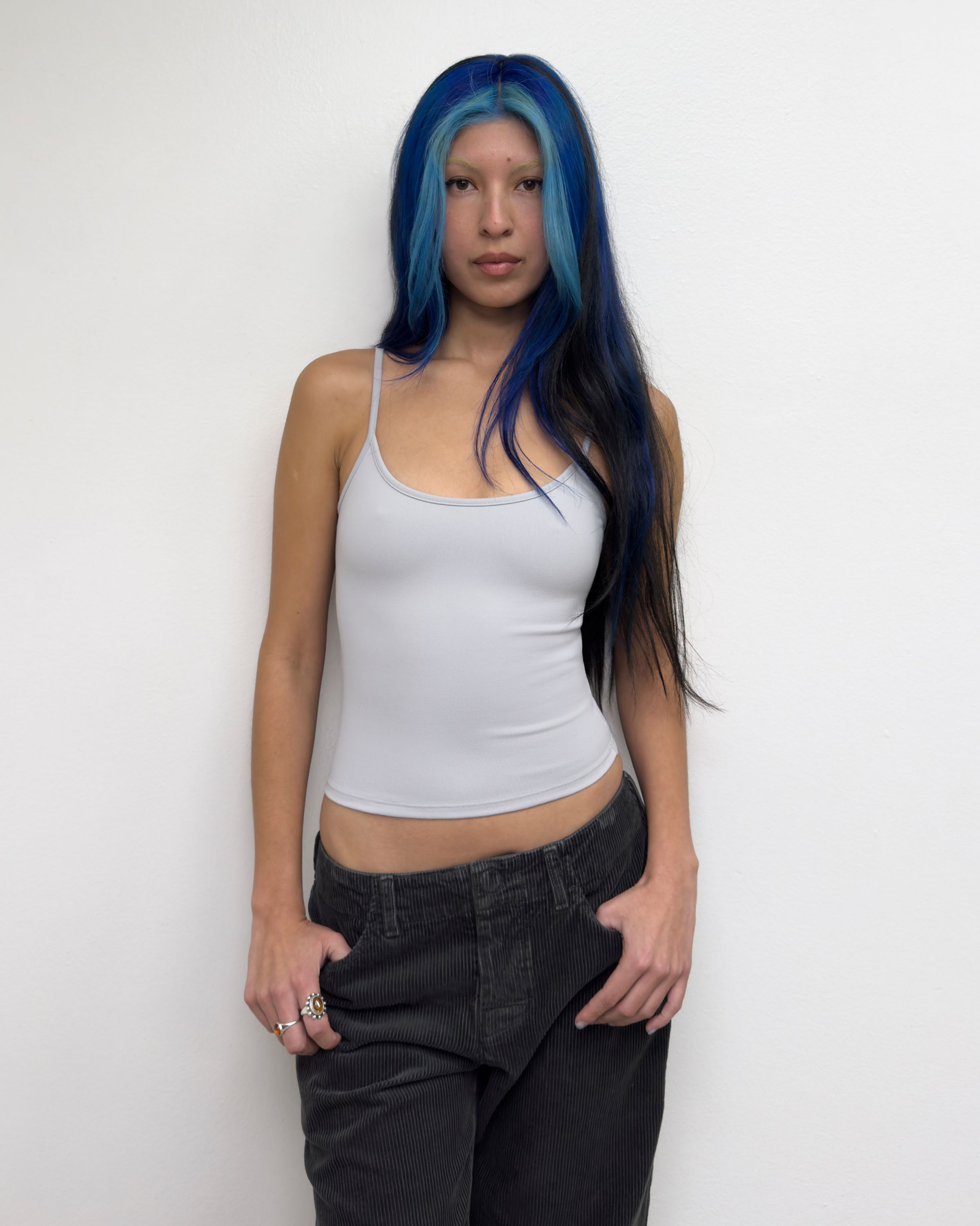 Tank Air SS25 Essentials shot in Los Angeles by Tank Air. Model wearing Studio Tank in Mist against white wall.