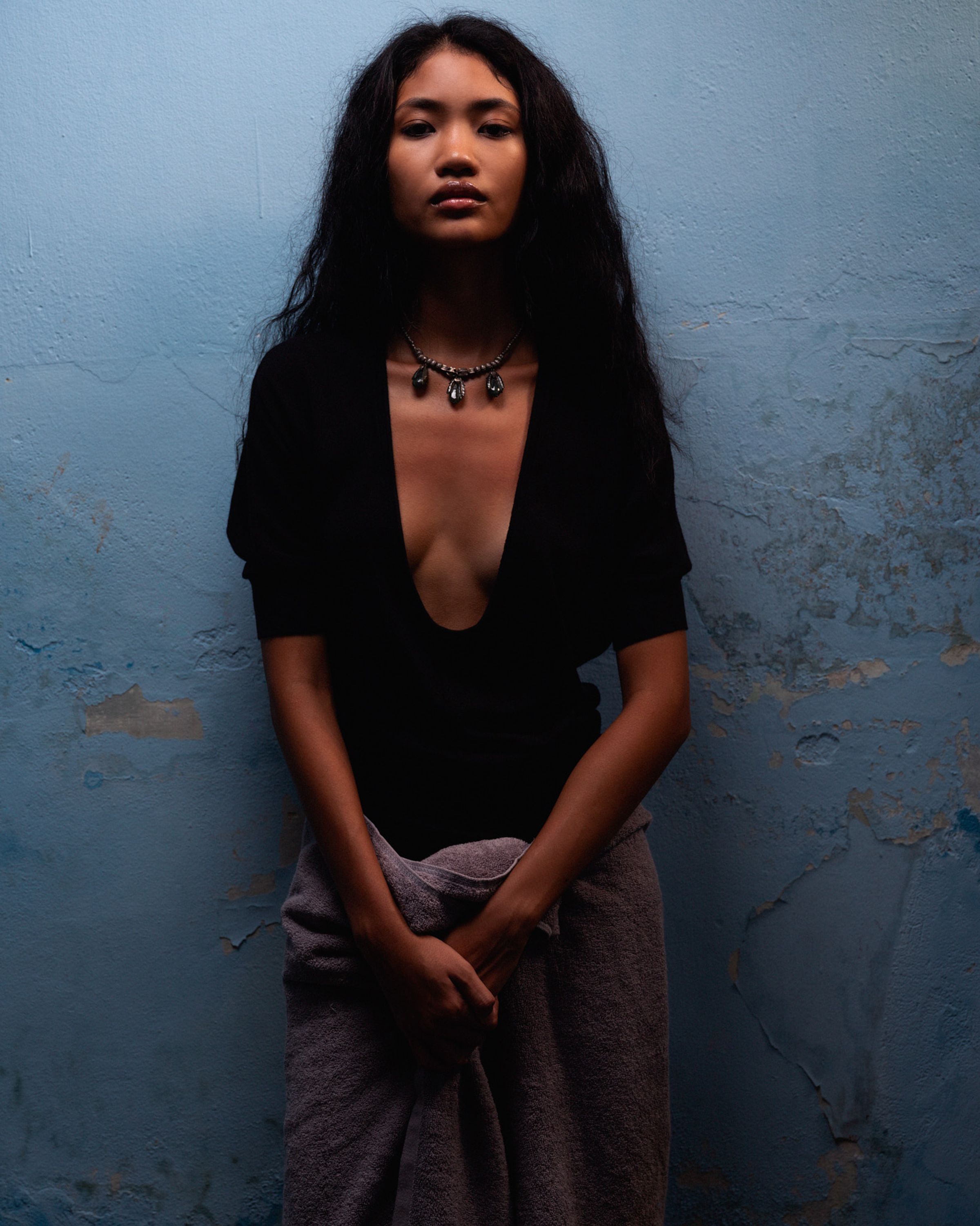 Tank Air SS25 ready-to-wear shot in Bangkok by Erika Kamano & Tank Air. Model wearing the Raindrop Knit in Black while leaning on wall.